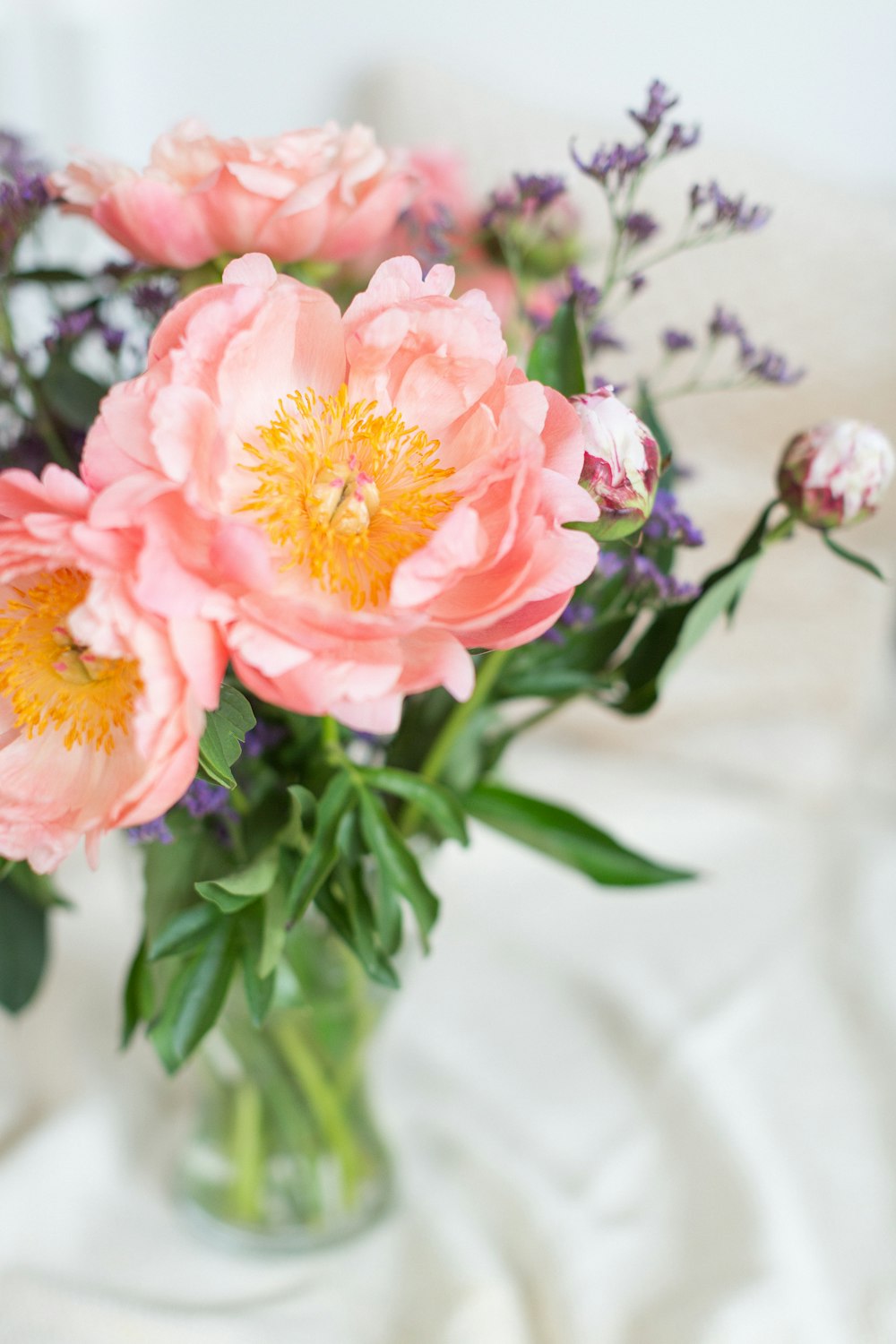 un vaso pieno di fiori rosa in cima a un tavolo