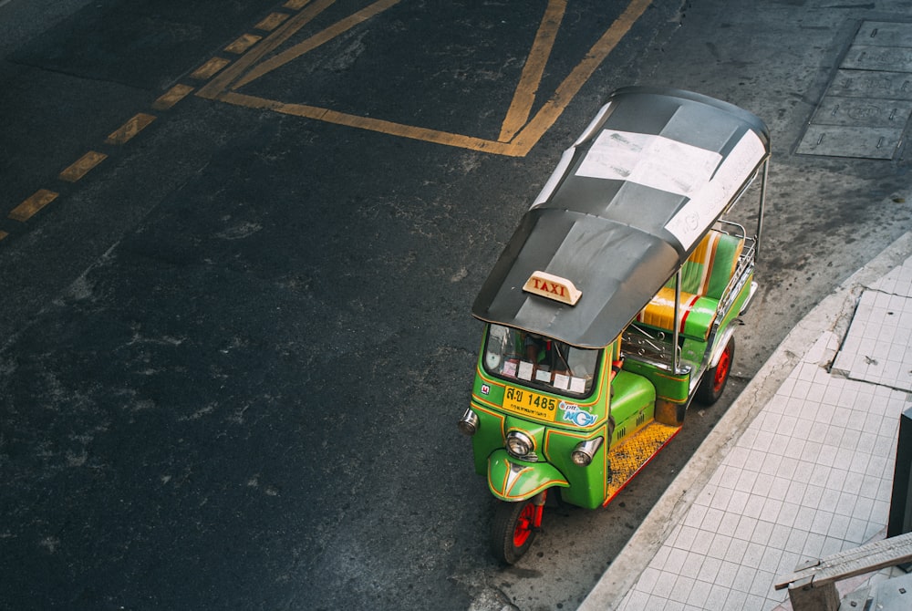 green and yellow auto rickshaw on road during daytime