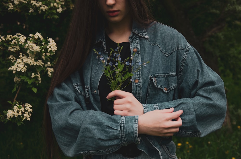 woman in blue denim jacket standing near green plants during daytime
