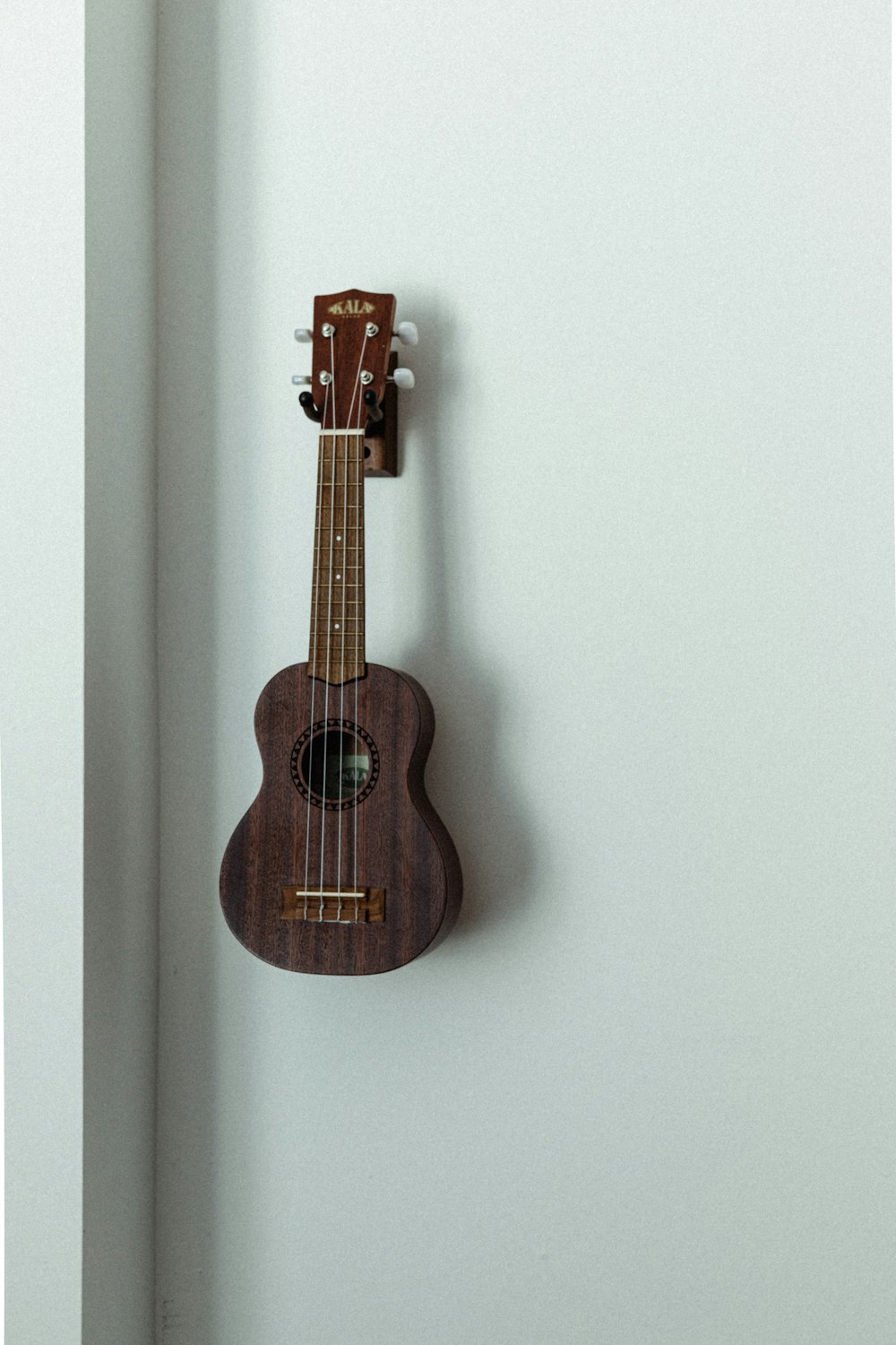 brown acoustic guitar on white wall