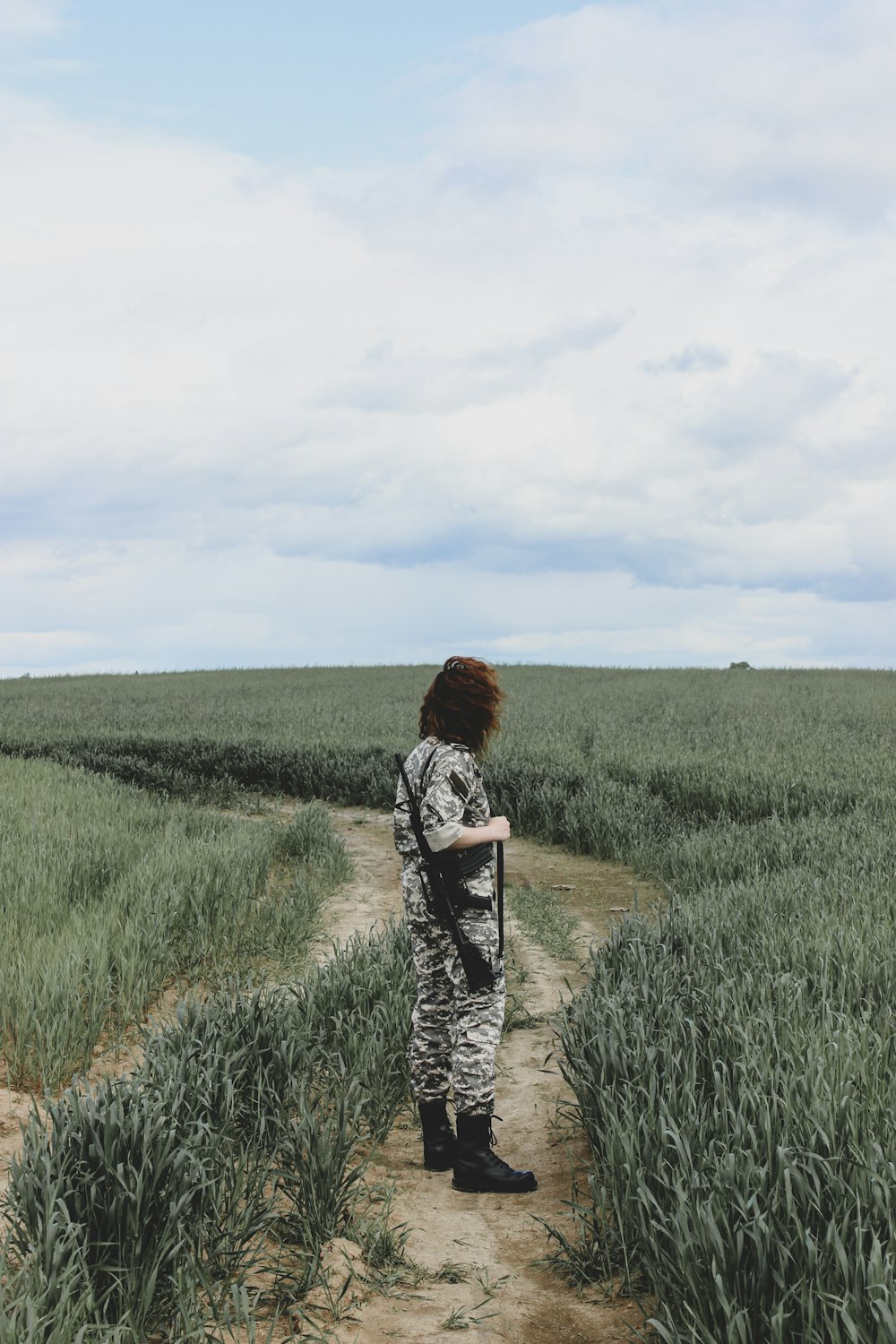 woman in black and white long sleeve shirt standing on green grass field during daytime