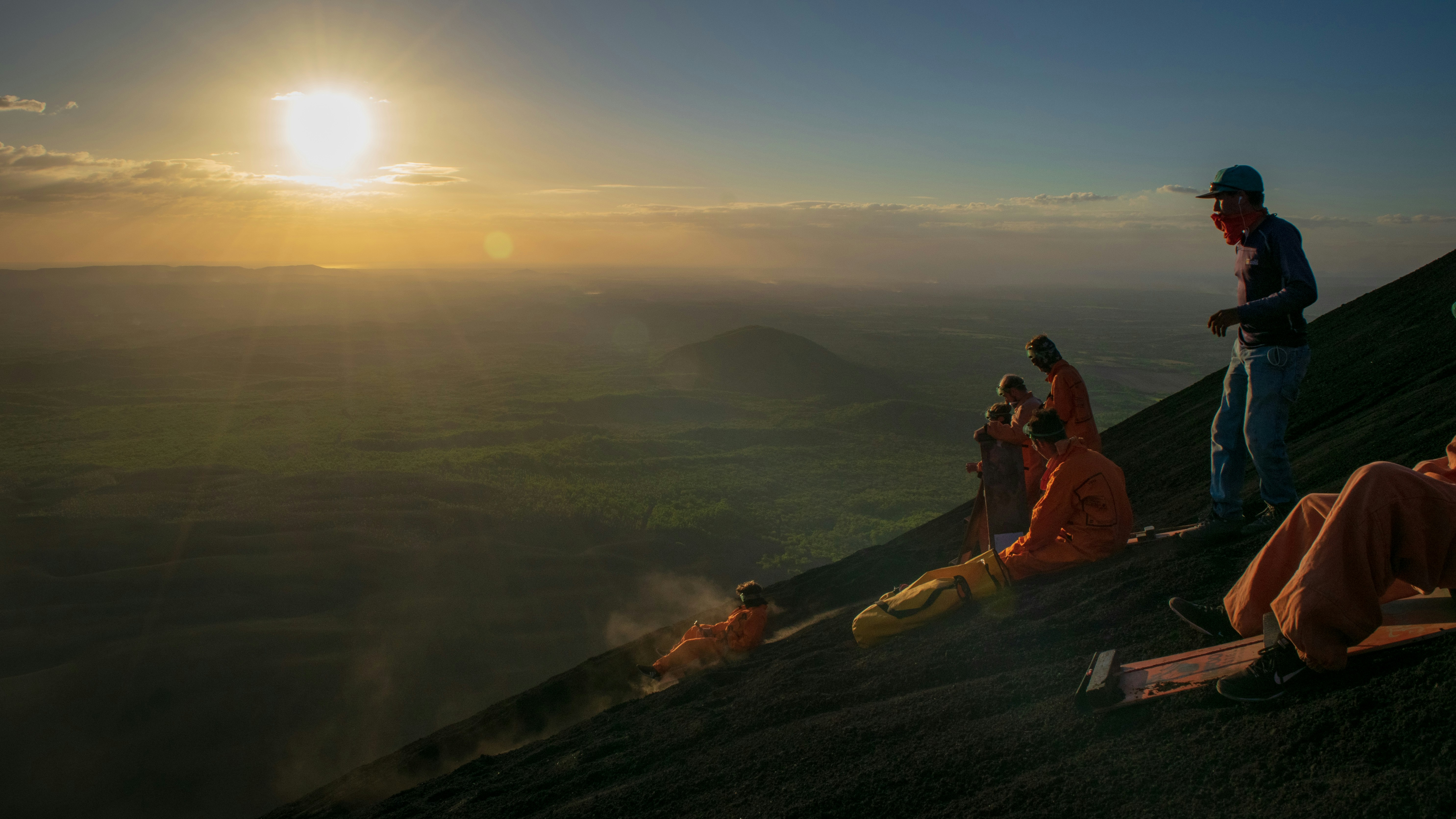 3 person sitting on brown rock during daytime