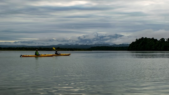 yellow boat on body of water during daytime in Ōkārito Lagoon New Zealand