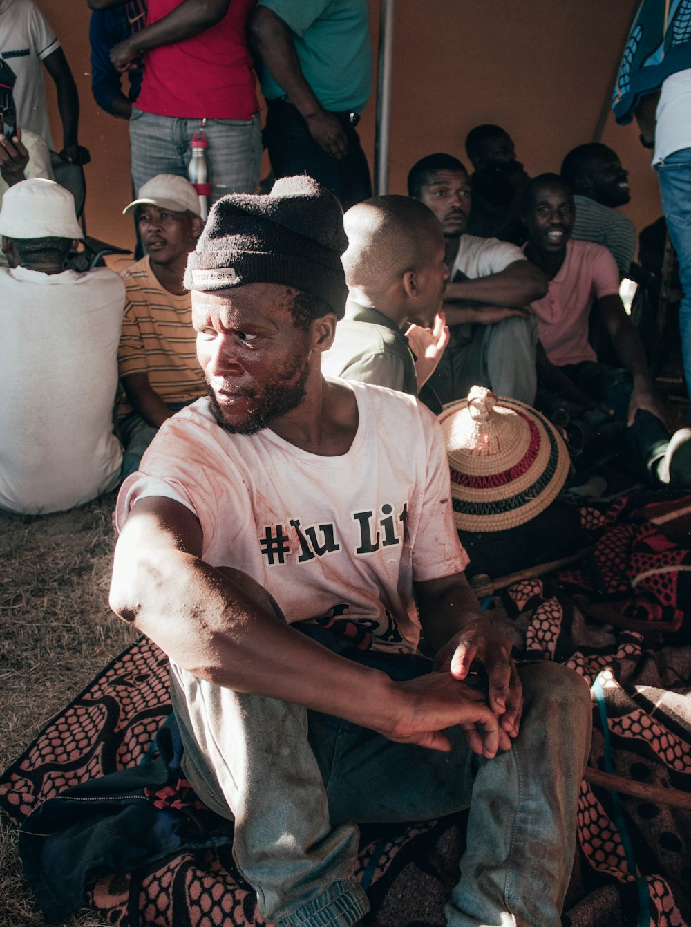 a man sitting on the ground in front of a group of people