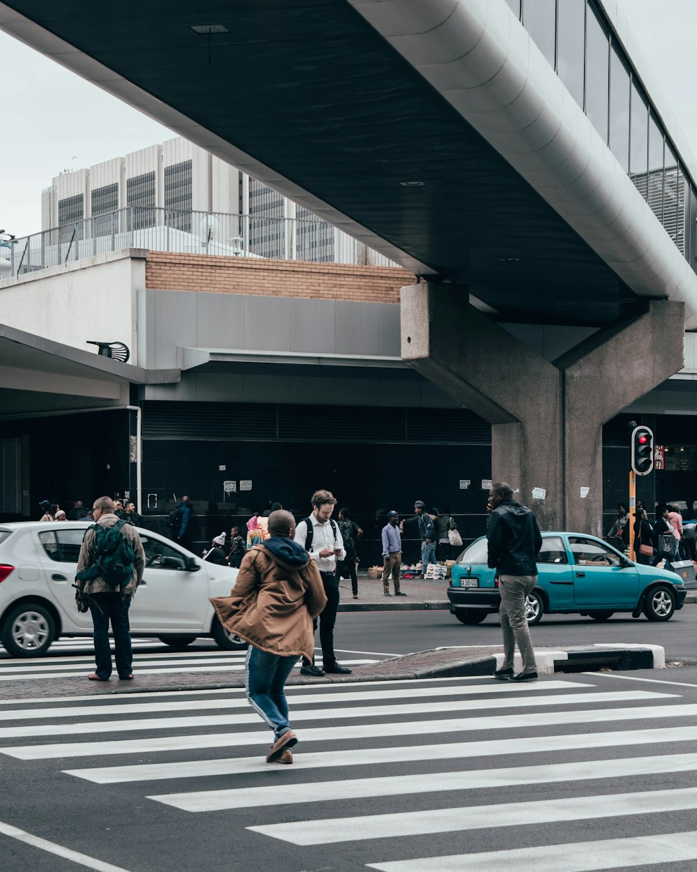 woman in brown coat walking on pedestrian lane during daytime