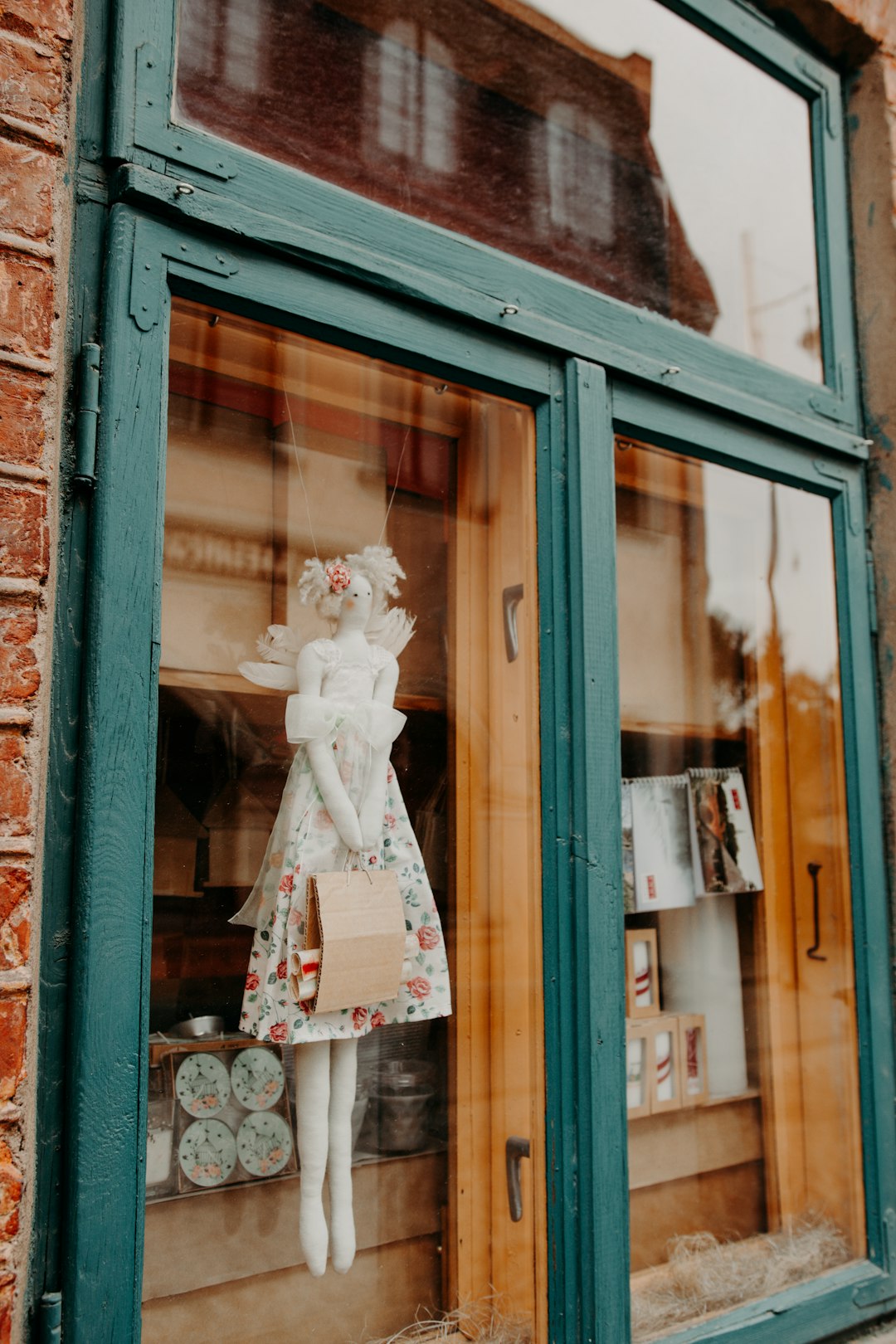 woman in white dress figurine on brown wooden framed glass window
