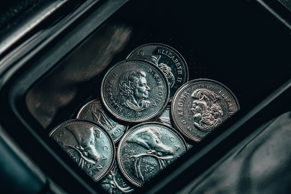 silver round coin on black surface