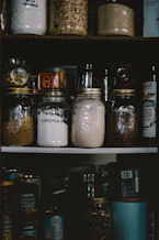 two clear glass jars on white shelf