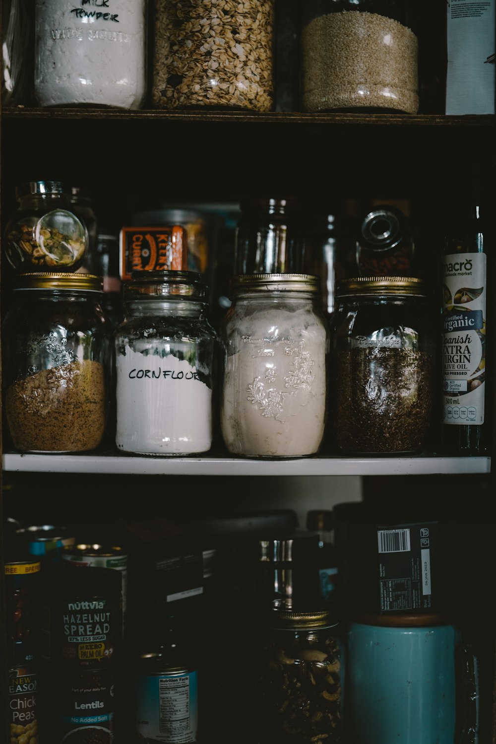 two clear glass jars on white shelf