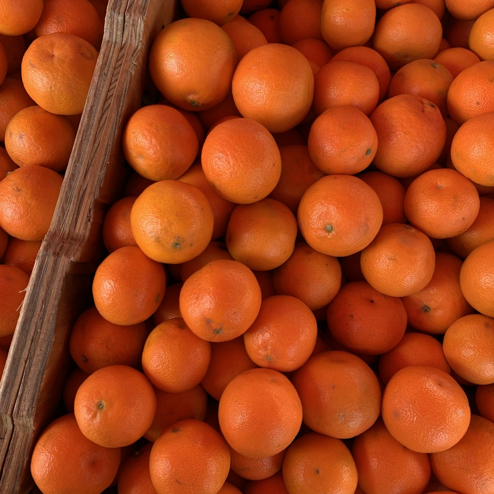 orange fruits on brown wooden crate