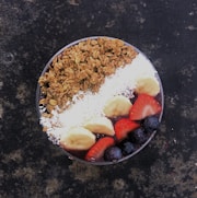white rice with sliced strawberries and brown nuts on white ceramic plate