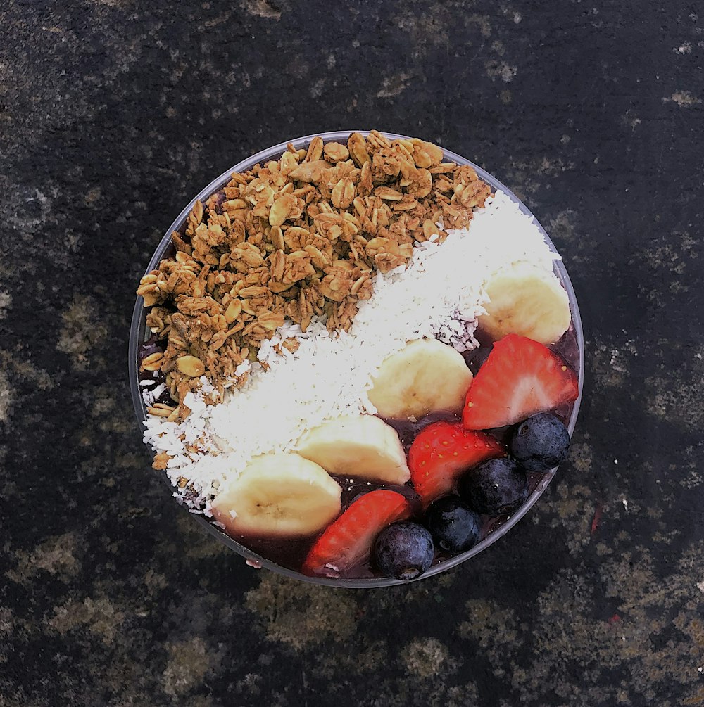 흰색 세라믹 접시에 얇게 썬 딸기와 갈색 견과류를 곁들인 흰 쌀