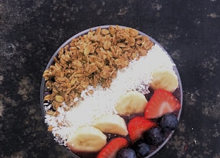 white rice with sliced strawberries and brown nuts on white ceramic plate