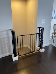 A child-safe expandable gate installed in a doorway, showing its flexible fit.