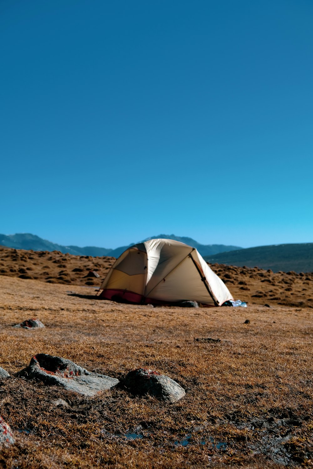 white and gray tent on brown sand under blue sky during daytime