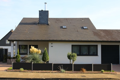 Cozy single-family house with a garden and a driveway under a clear sky.