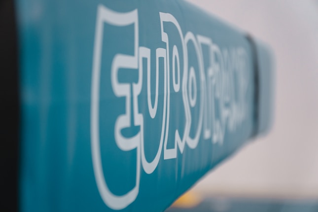 Bold white text reading 'EURO' stenciled on a soft blue background, with a modern font style. The image has a shallow depth of field, causing much of the text to blur into the background.