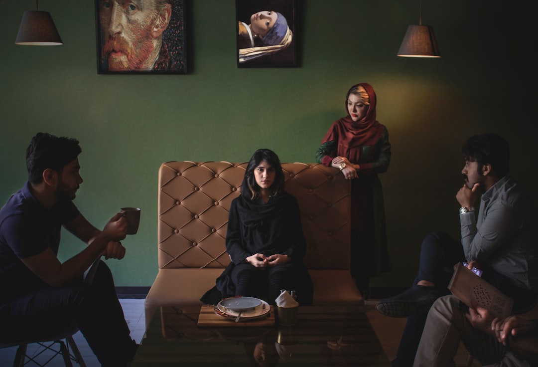 woman in black hijab sitting on brown couch