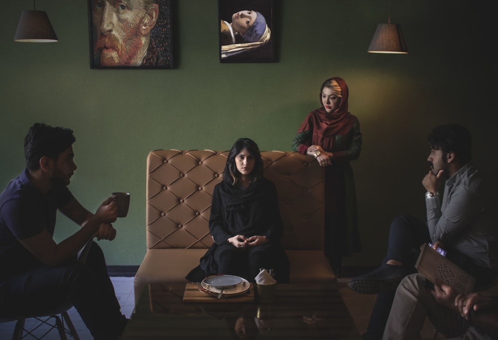 woman in black hijab sitting on brown couch