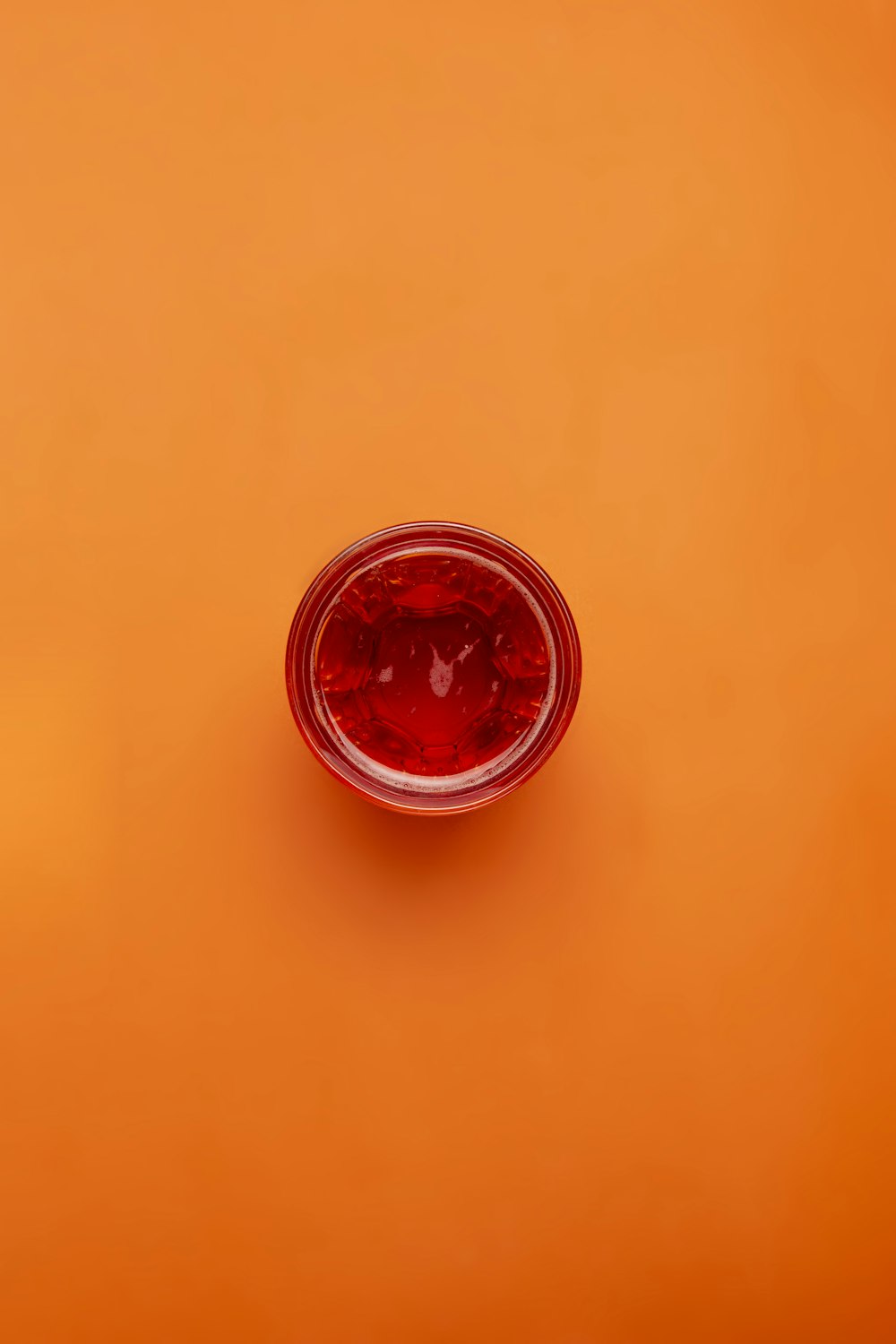 red round glass on orange surface