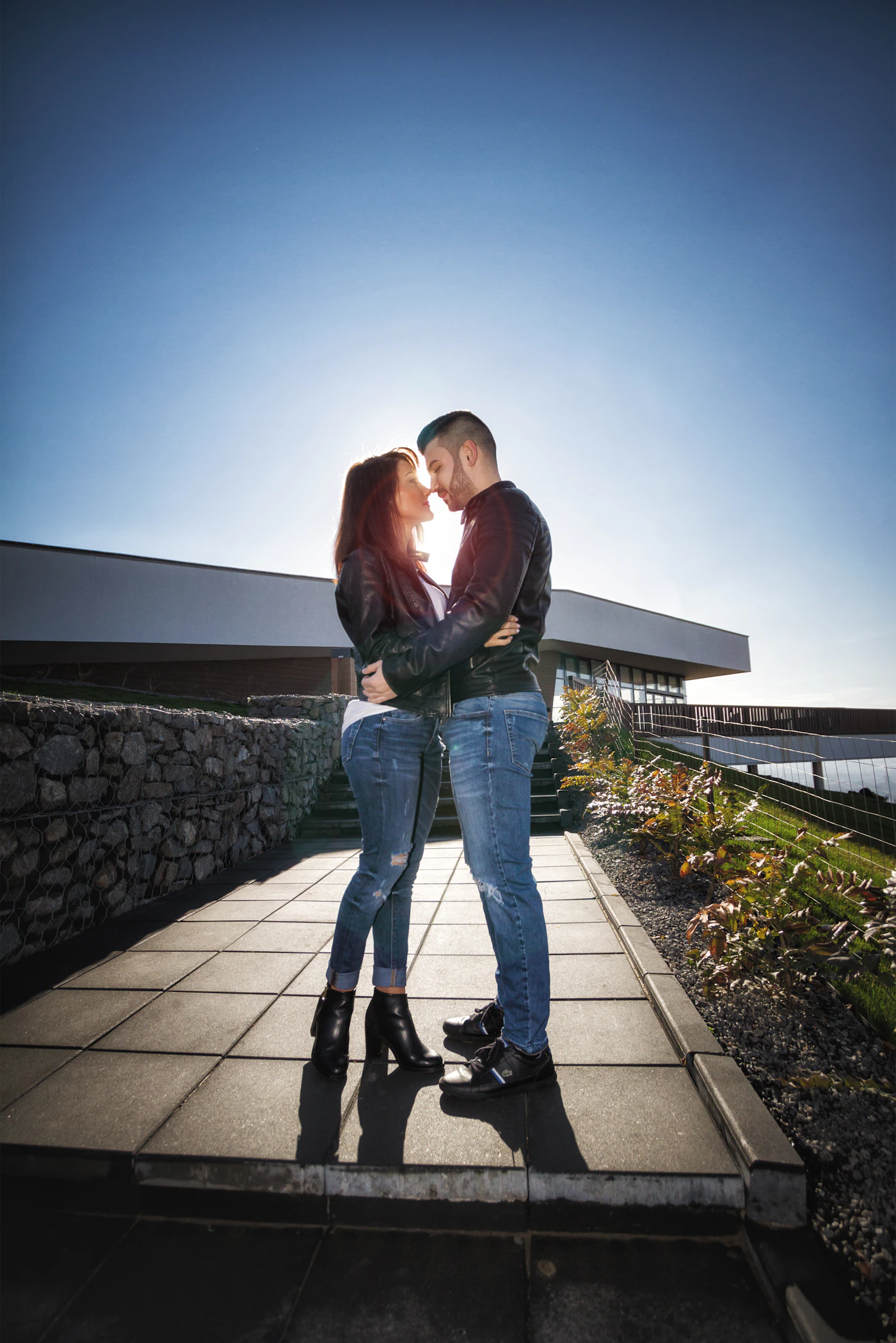 Couple in a natural outdoor setting near water showing the kind of genuine intimate moment that documentary wedding photography captures in any weather condition