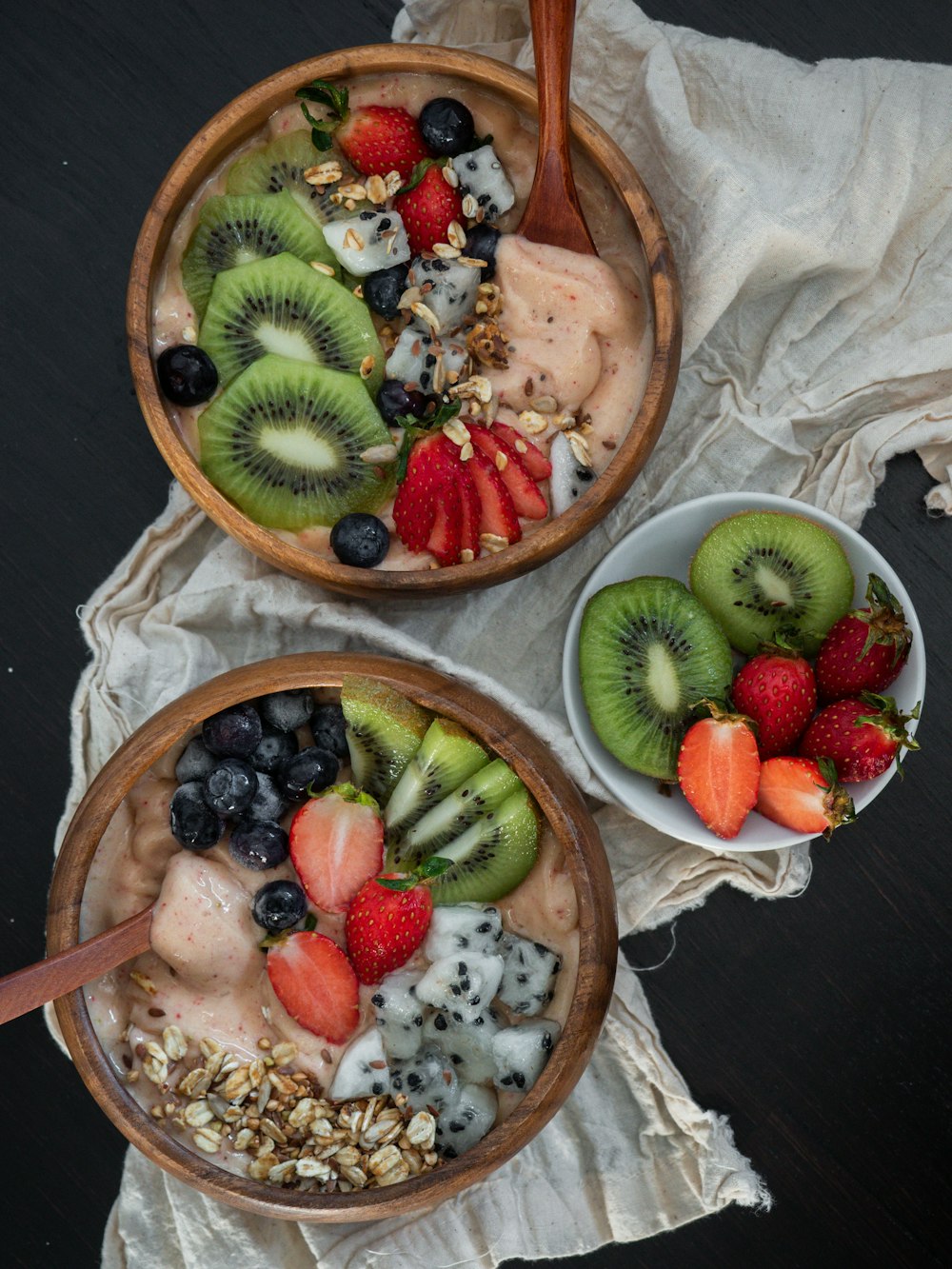 rodajas de kiwi y fresa en un bol de madera marrón