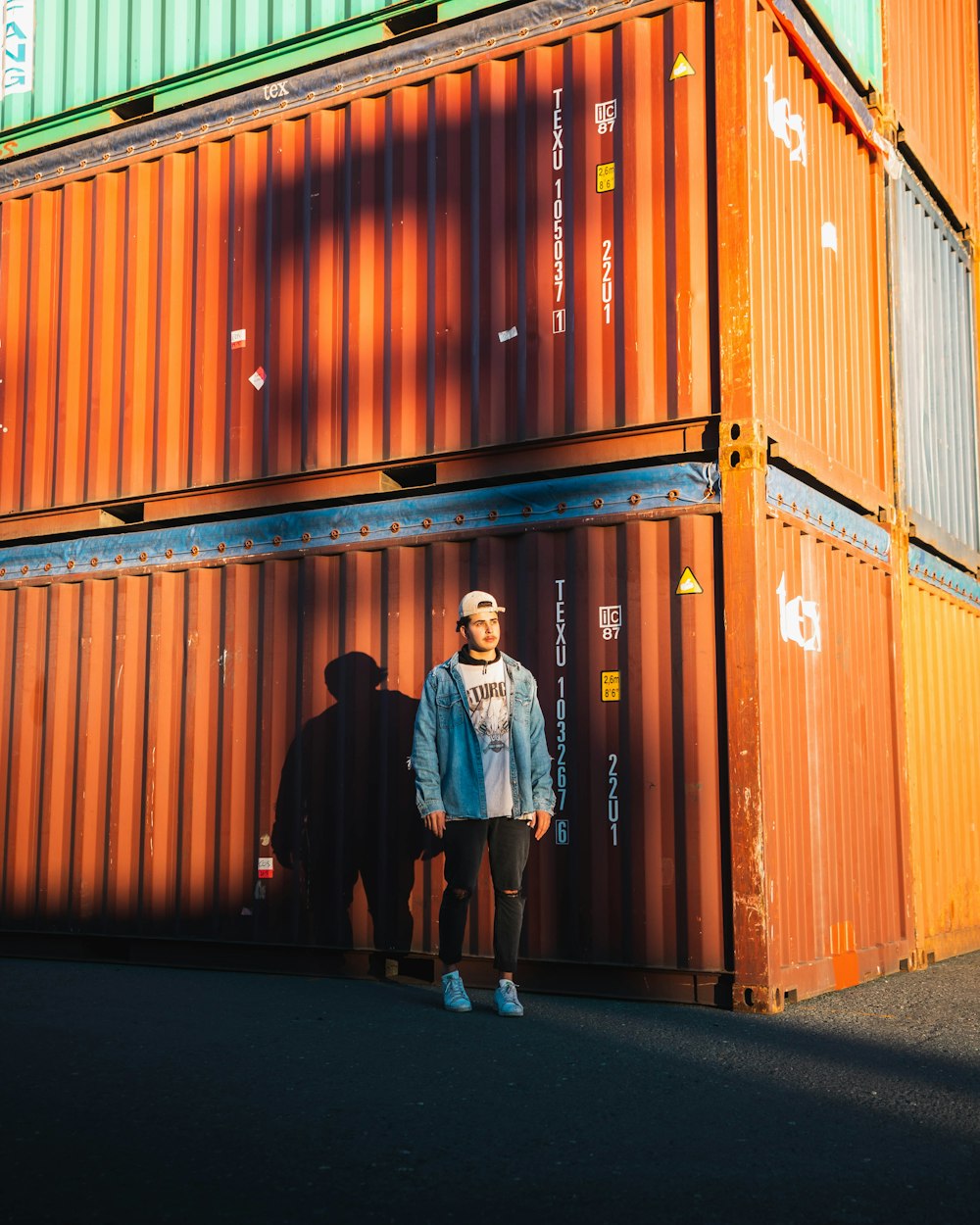 woman in black dress standing beside orange steel wall during daytime