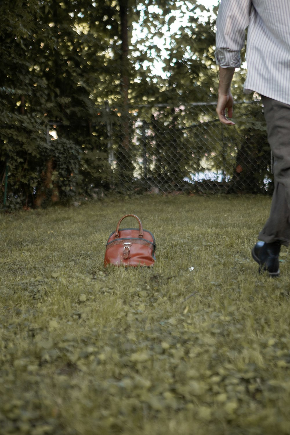 person in white shirt and black pants standing on green grass field during daytime