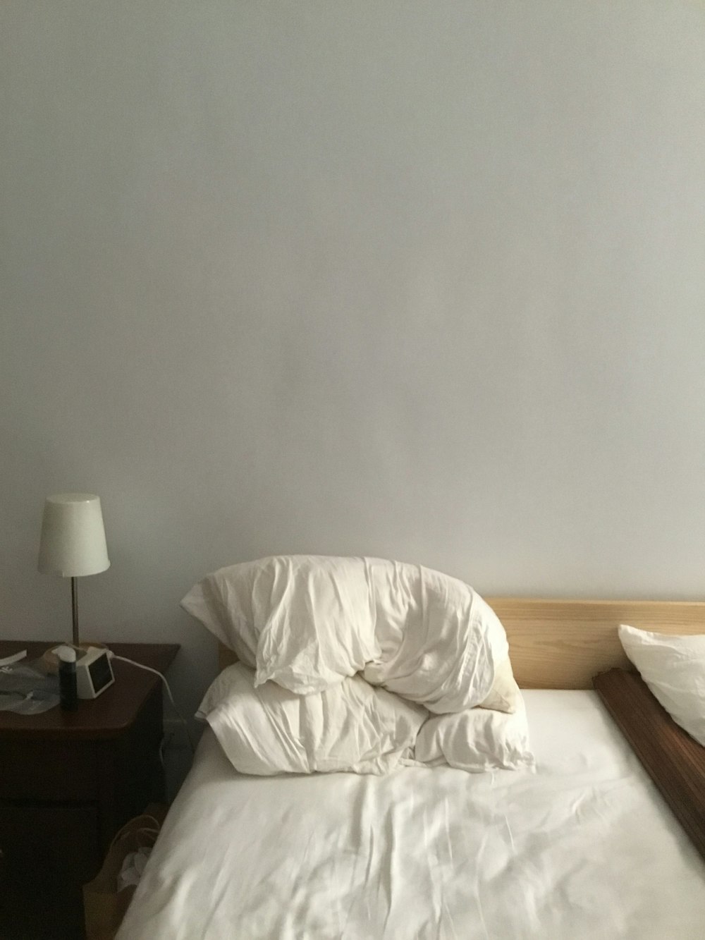 white bed linen near brown wooden table