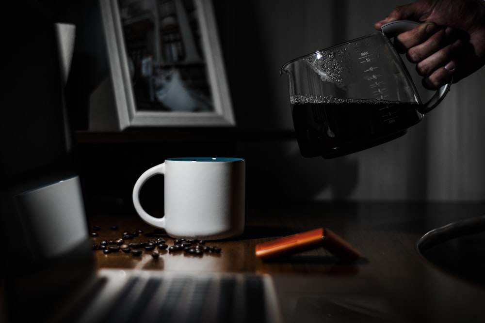 white ceramic mug beside clear glass mug on brown wooden table