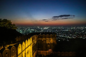 A rooftop view overlooking a historic fort at sunset.