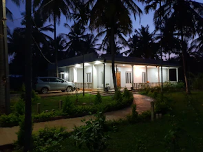 A modern villa garden with palm trees and decorative lighting in Jeddah.