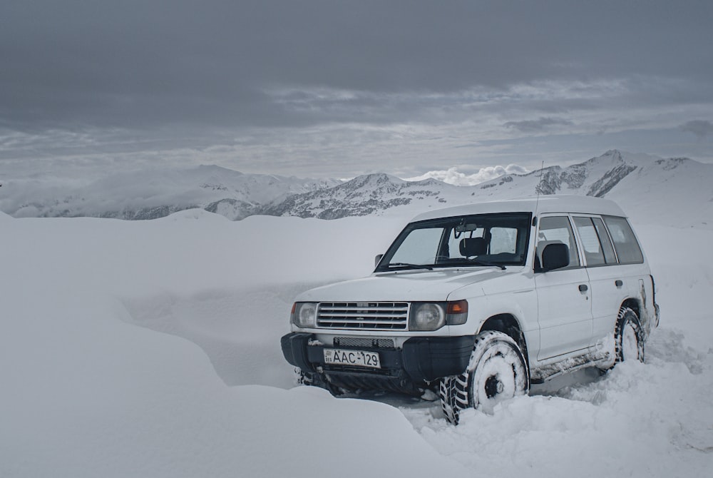 昼間は雪に覆われた地面に白いSUV