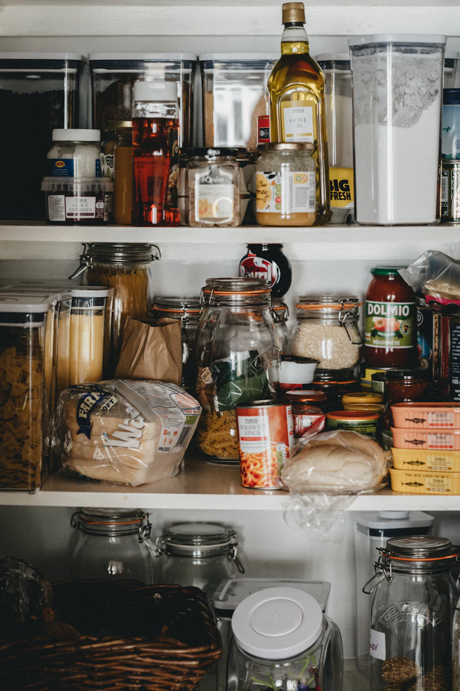 Clear glass jars lined up on a white pantry shelf