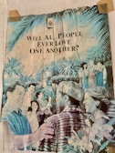 A vintage poster displaying a diverse group of people joyfully interacting in a lush, tropical setting, surrounded by greenery and tropical plants. The text on the poster poses the question, 'Will all people ever love one another?'
