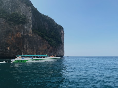 Speedboat cruising on clear blue coastal waters under sunny sky.