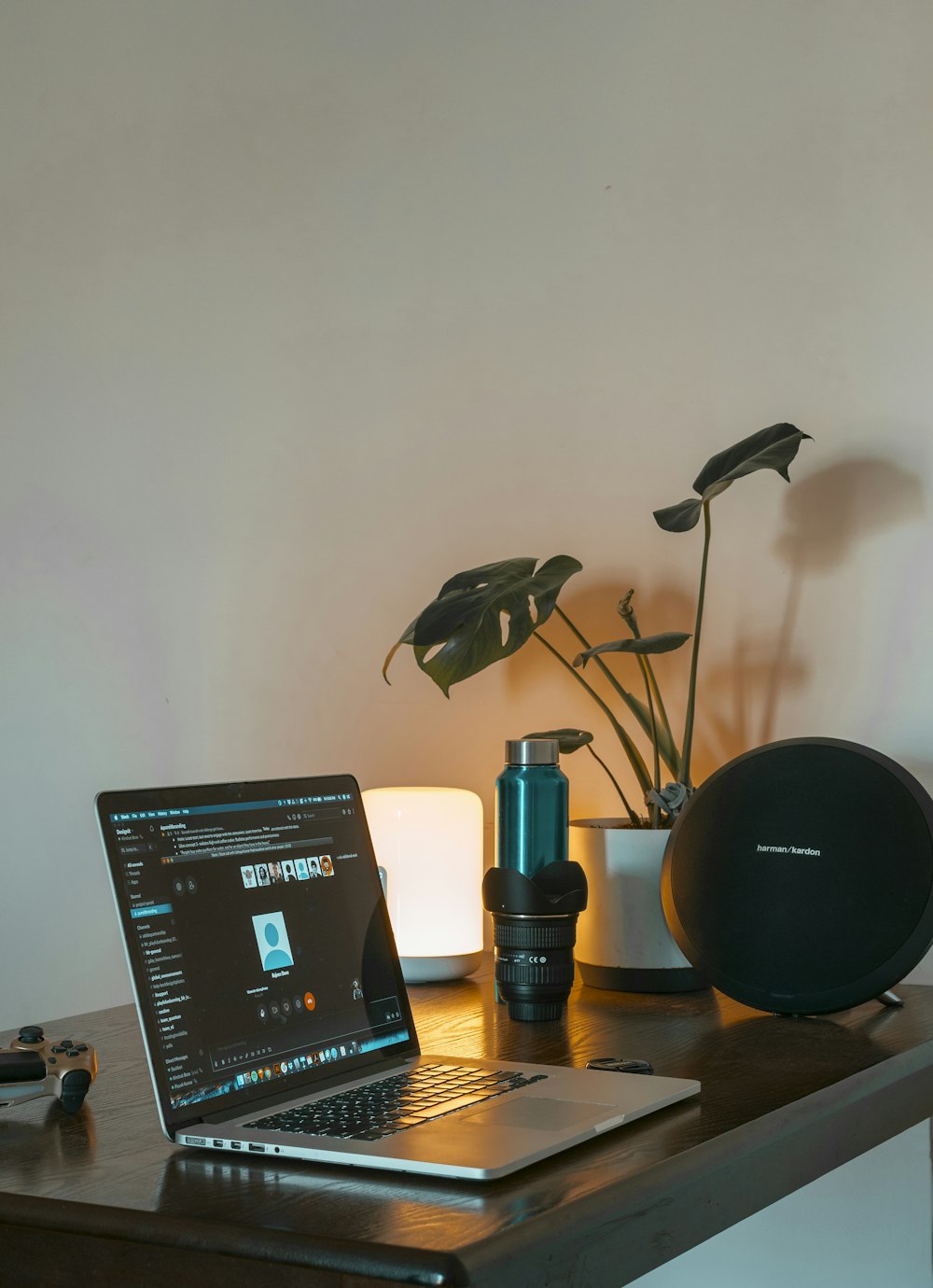 black and silver round portable speaker beside black laptop computer