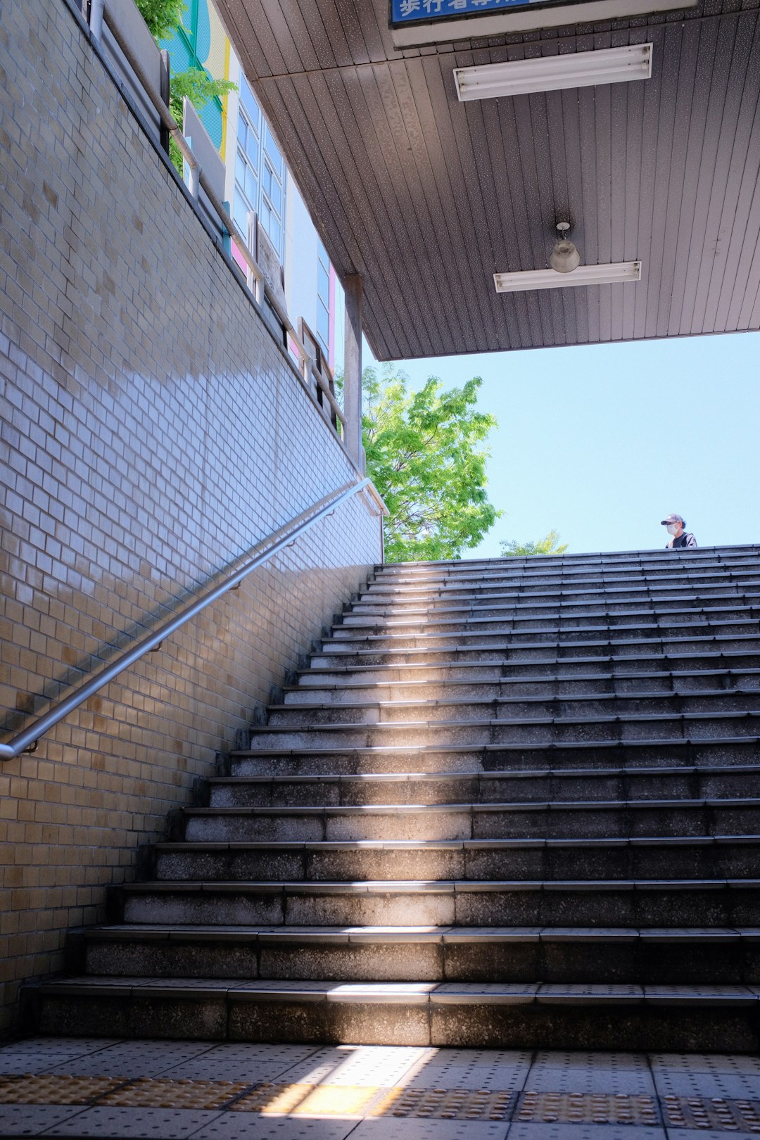 person in white shirt walking on gray concrete stairs during daytime