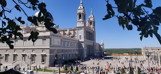 people walking on street near white concrete building during daytime in Catedral de la Almudena Spain
