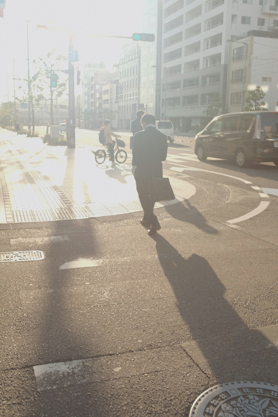 man in black jacket walking on sidewalk during daytime