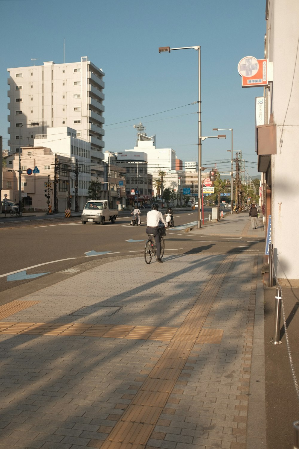 man in white shirt riding bicycle on road during daytime