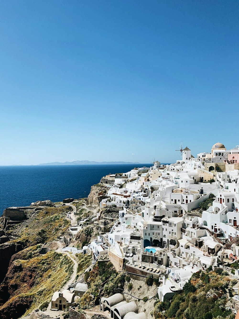 white concrete houses on mountain near sea during daytime