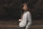 woman in gray zip up jacket standing on brown field during daytime