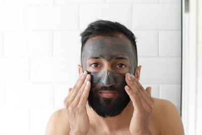 Close-up of hands applying a calming facial mask in a serene setting