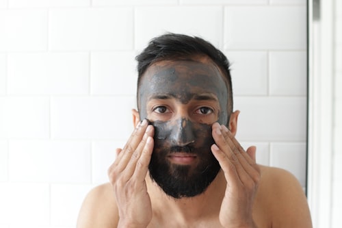 Man with clay face mask applied