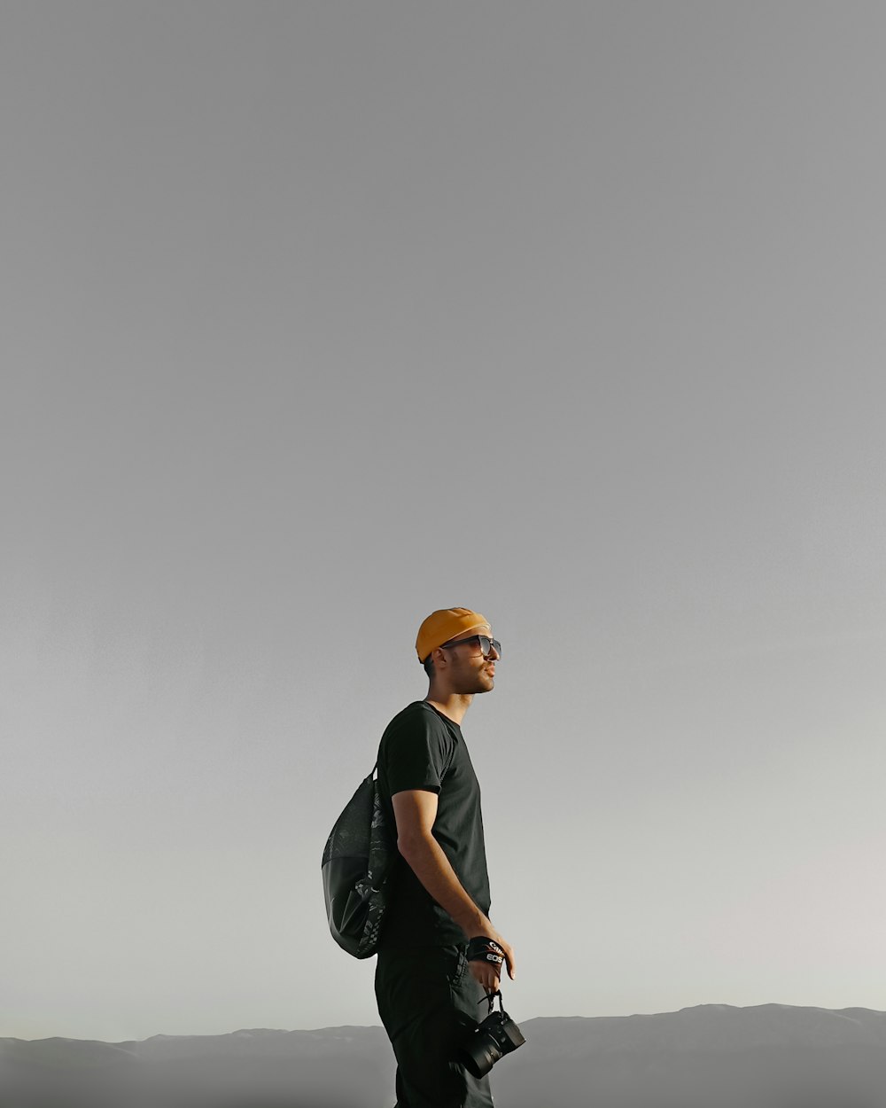 man in black t-shirt and brown cap