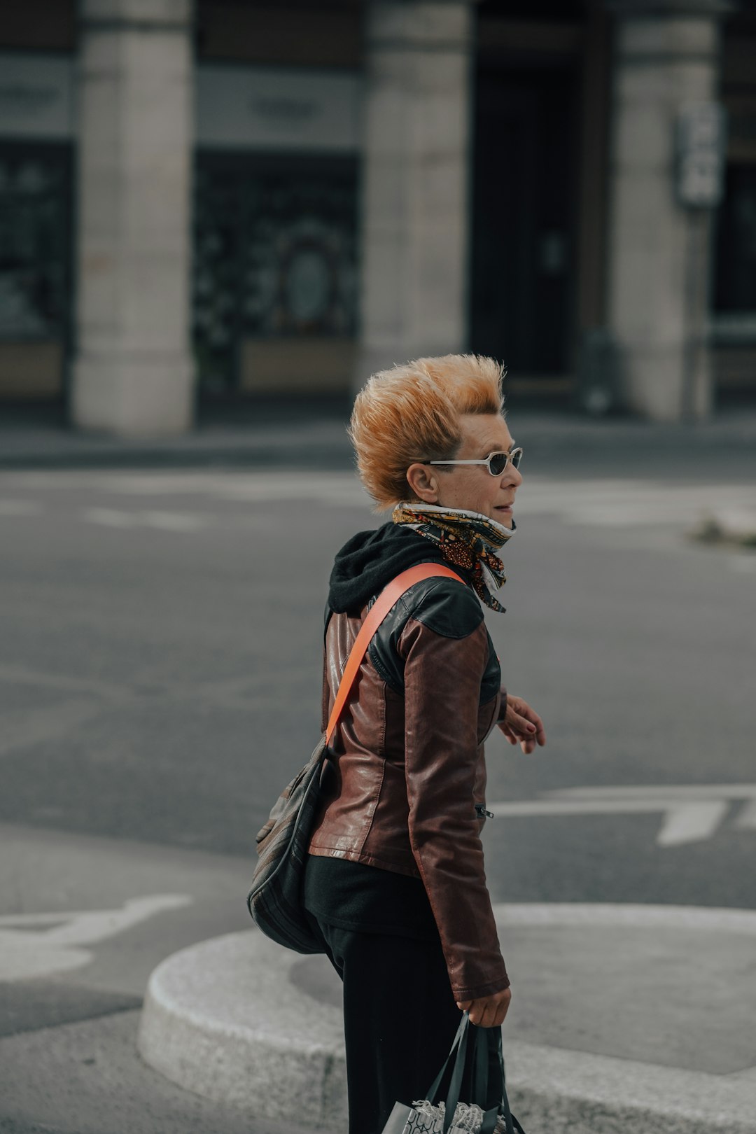 woman in brown leather jacket walking on street during daytime