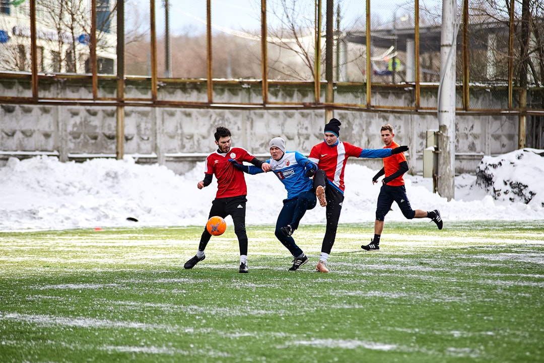 group of children playing soccer on green grass field during daytime