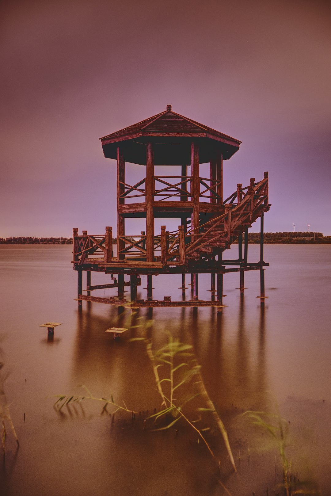 brown wooden dock on body of water during sunset