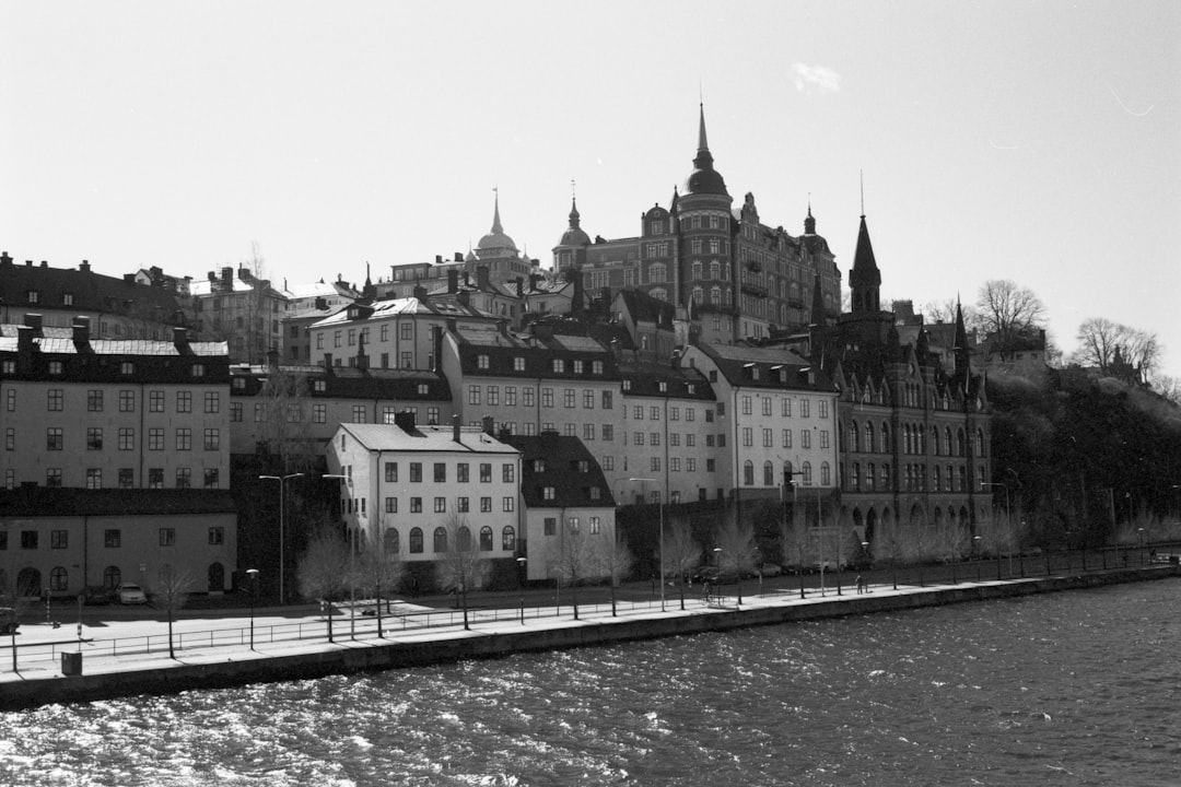 grayscale photo of concrete building near body of water